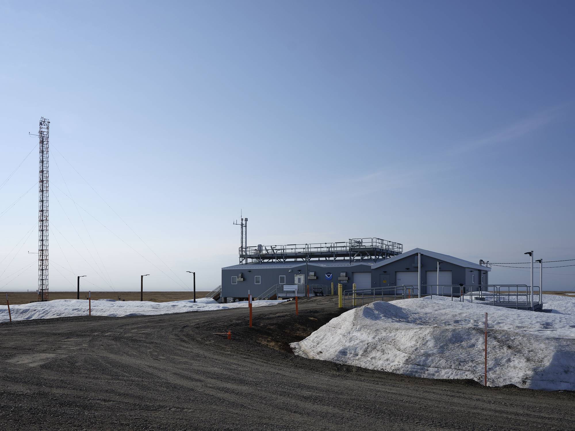 A blue building with a sign that reads NOAA surrounded by snow